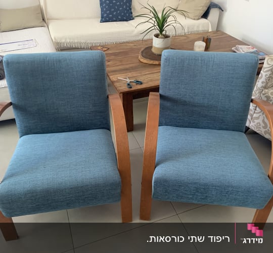 שני כיסאות מרופדים בכחול עם מסגרת עץ